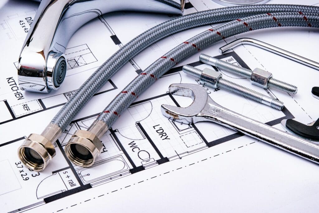 Plumbing tools and equipment on a home blueprint